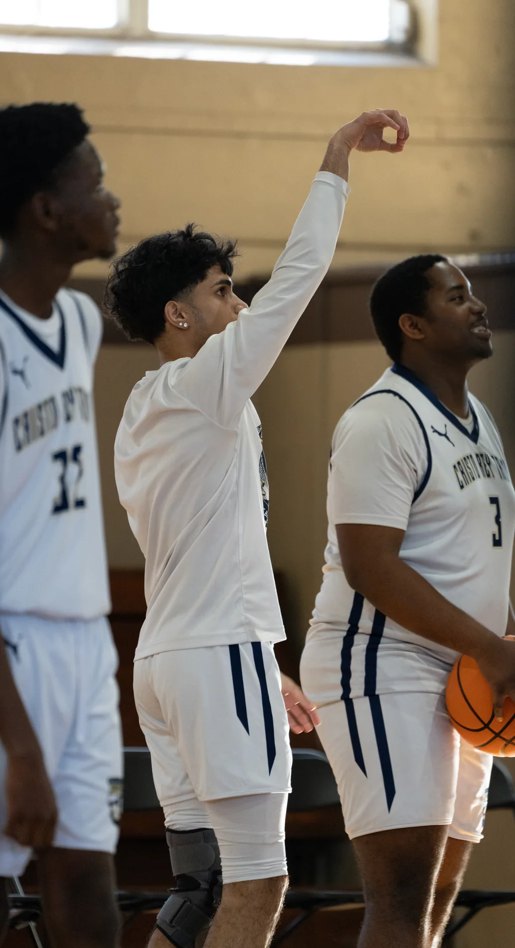 Basketball teammates celebrating near the bench