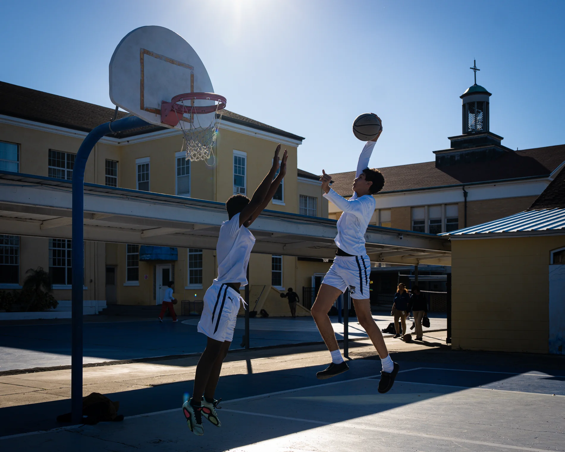 Basketball players meeting above an outdoor rim