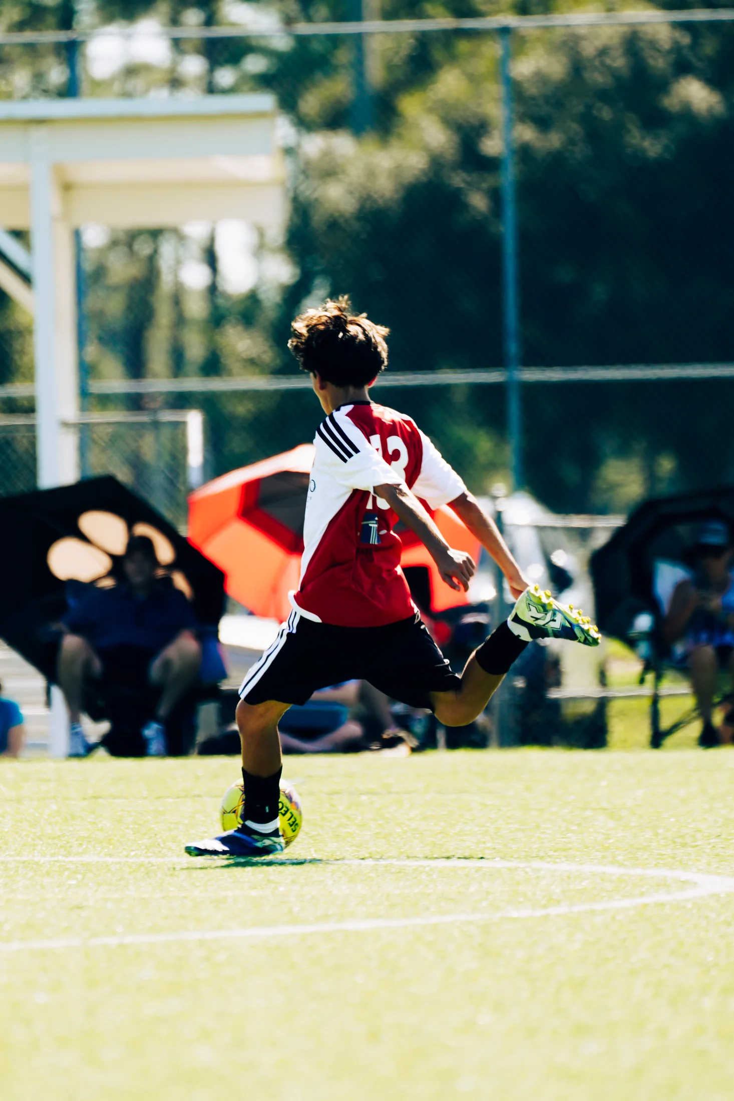 Soccer player striking the ball during match action